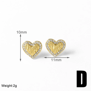 Macro detail of gold-plated heart stud earrings with pave crystals and size markings