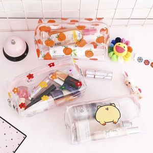Detail view of transparent PVC toiletry bags with cute orange, floral, and pig prints