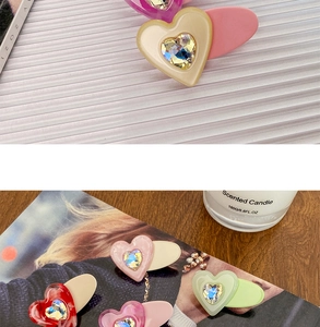 Close-up of candy-colored heart hair clips with central rhinestone on a lifestyle background