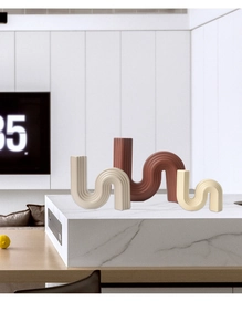 Detail view of modern S-shaped ceramic vases with vertical wave texture in three colors