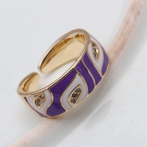 Detail of gold evil eye ring with purple enamel feather pattern and zircon stones