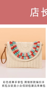 Detail of straw woven envelope clutch featuring colorful fringe tassels and leather wristlet