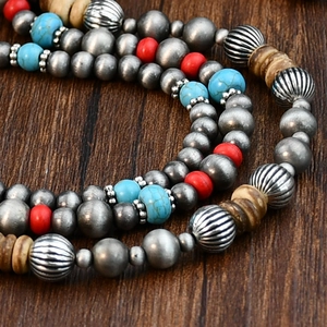 Ethnic Navajo-style turquoise beaded necklace with cross pendant on rustic wood surface