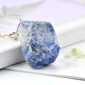Macro shot of natural raw lapis lazuli stone with silver metal clasp on white stand