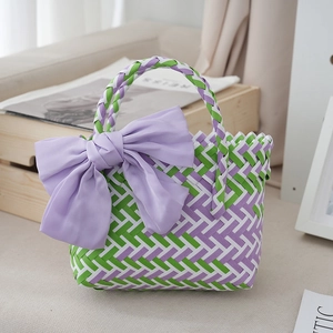 Close-up of woven gift bag with purple silk bow and colorful hand-woven texture