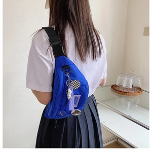 Detail of blue nylon crossbody bag with dog pendant and space travel ribbon
