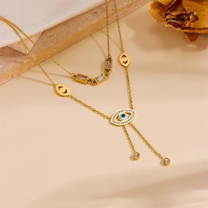 Detailed shot of double-layered gold evil eye necklace with crystals on stone base