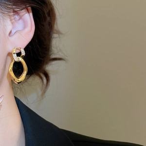 Detailed close-up of gold interlocking double loop earrings with micro-pave cubic zirconia