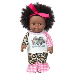Detail of African baby doll with curly hair, pink bow, and leopard print raglan outfit