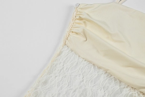 Detail of elegant off-white lace stitching and ruched satin fabric on a sexy dress