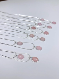 Detail der S925 Silber-Schlangenkette mit ovalen rosa Chalcedon-Anhängern auf Weiß