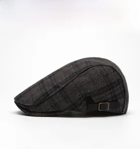 Detail view of vintage dark plaid wool beret side with adjustable strap and metal buckle