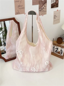 Detail of pink floral embroidery on a textured canvas tote bag for daily commute