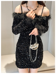 Close-up of black sequin off-shoulder dress with elegant feather trim on cuffs