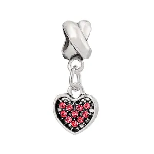 Macro detail of silver heart charm with ten red crystals for DIY bracelets