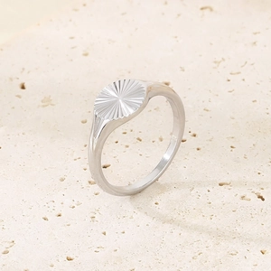 Anello girasole in acciaio inossidabile argento con trama radiale su base beige neutra