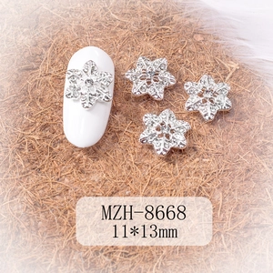 Macro view of 11x13mm silver snowflake nail charms with crystals for winter DIY manicure