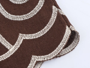 Detail of ethnic embroidered pattern on straight trousers with thick textured fabric