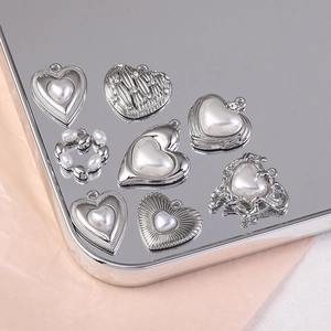 Détail de breloques cœur argentées avec perles pour la création de bijoux DIY et accessoires