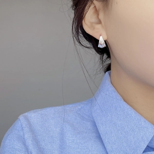 Minimalist S925 sterling silver shell earrings with ribbed texture worn by a model