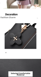 Detail of elegant black leather handbag featuring flower charm and pebble grain texture