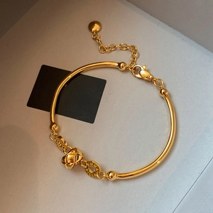 18K gold plated bamboo bracelet with quilted ball charm and round brand tag