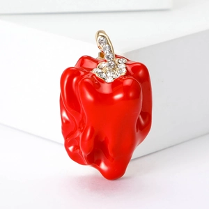 Detail of red enamel chili brooch with gold base and sparkling crystal rhinestones