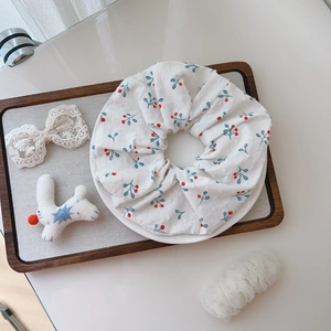Floral print cotton scrunchie with red cherries on a white background with accessories