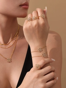 Dettaglio di elegante set di gioielli a quadrifoglio in oro con pietre di zircone 5A