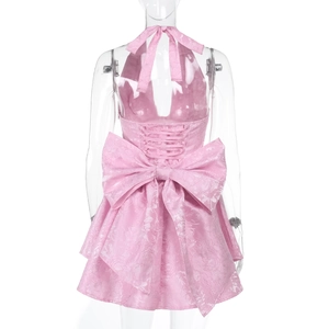 Detailed back view of pink jacquard halter dress with a large bow and tiered skirt