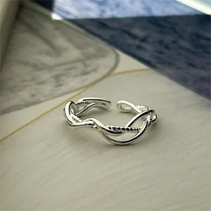 Detailed close-up of a 925 sterling silver intertwined ring with beaded texture accents