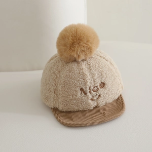 Détail de la texture polaire, visière en velours et broderie Nice sur la casquette bébé