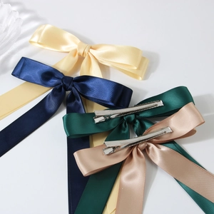 Lot de quatre barrettes à nœud en satin brillant jaune, bleu marine, émeraude et doré champagne