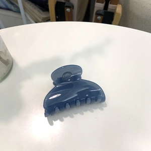 Blue translucent heart hair claw clip with simple design on white surface