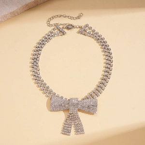 Detail of multi-row choker necklace with a large crystal butterfly bow and shiny rhinestones