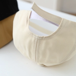 Close-up of adjustable velcro strap and fine stitching on beige cotton kids beret hat