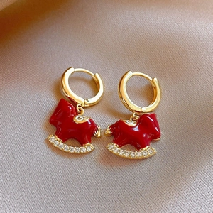 Détail de boucles d'oreilles cheval à bascule émail rouge avec zircons blancs