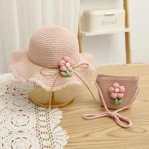 Detail of pink straw sun hat and matching flower bag set with lace and floral accents