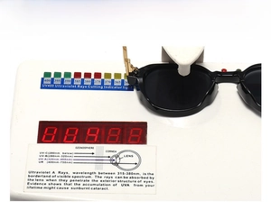 Close-up of narrow retro sunglasses on UV400 protection testing machine showing UV blocking