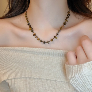 Vue détaillée du collier en pierre oeil de tigre irrégulière porté par un mannequin