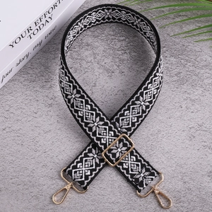 Detail of ethnic geometric pattern woven strap with premium gold metal hardware hooks