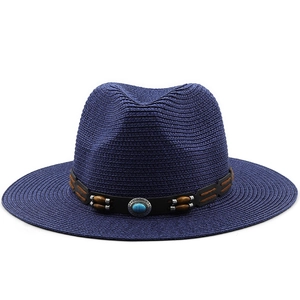 Detail of navy straw Panama hat featuring a leather band with turquoise and wooden beads