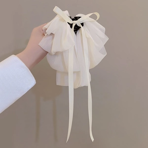 Detail of white chiffon ribbon hair claw with elegant multi-layer bow design