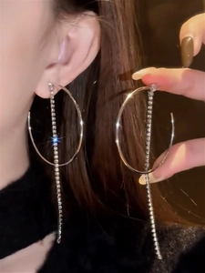 Detailed view of silver hoop earrings with long sparkling tassel and white cubic zirconia