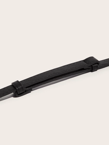 Macro detail of black Saffiano leather waist belt with fine cross-grain texture and loop