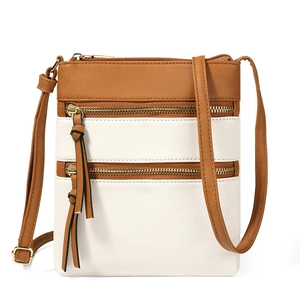Close-up of brown and white vertical crossbody bag showing multi-zippered pocket details