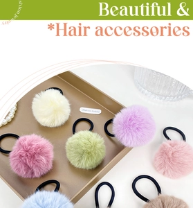 Flat lay of colorful plush fur ball hair scrunchies on a gold tray with pearl accents