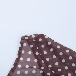 Gros plan détaillé sur un tissu en maille marron transparent à pois blancs élégants