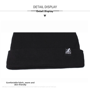 Close-up of black knitted beanie featuring sports tag and thick winter texture