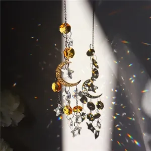Star and moon suncatcher with crystals casting colorful light reflections on dark background